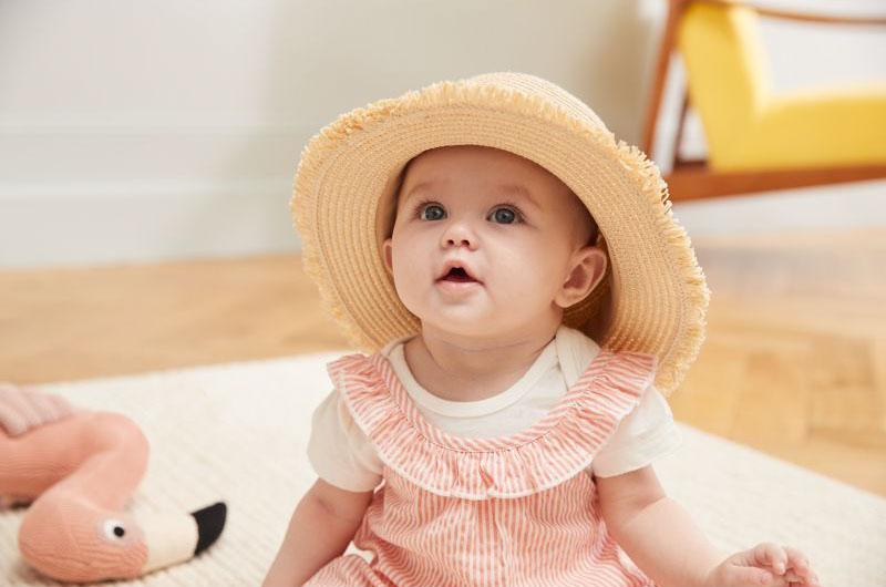 Một phụ nữ trẻ đang lựa chọn áo kiểu nữ cổ tim cách điệu tại cửa hàng thời trang, cân nhắc giữa các màu sắc và kiểu dáng khác nhau