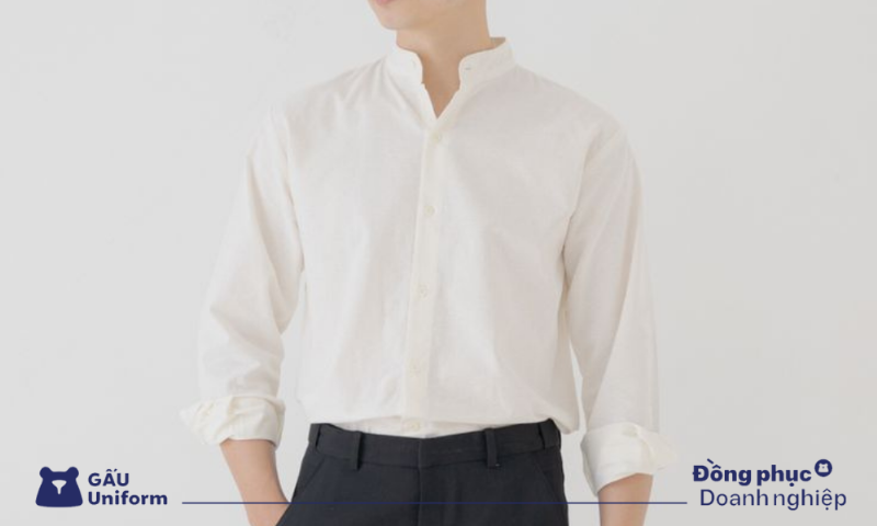 Nữ doanh nhân mặc áo cardigan ngắn màu kem bên ngoài áo sơ mi trắng và quần tây ống rộng, toát lên vẻ thanh lịch và chuyên nghiệp