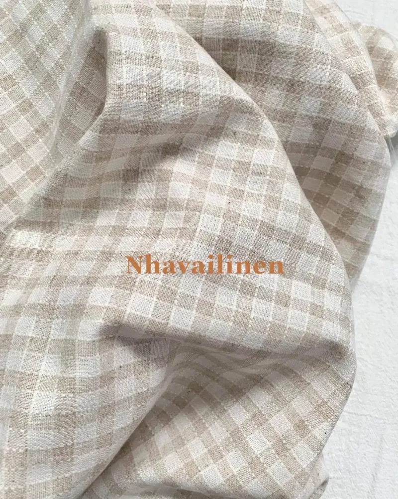 Một người phụ nữ trẻ đang thư giãn trên ghế sofa, mặc một bộ đồ cotton màu pastel được phối hợp tinh tế, thể hiện phong cách mặc ở nhà đẹp và thoải mái.