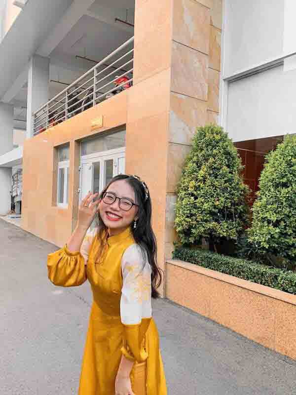 Áo dài tay lỡ loe nhẹ màu hồng pastel với nơ cài duyên dáng