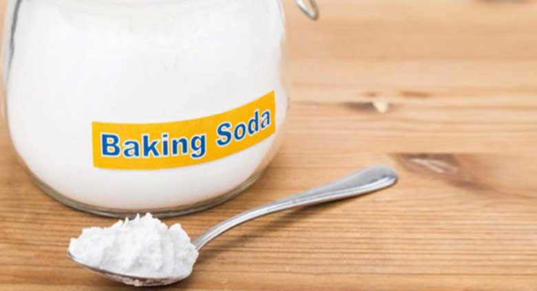 Hỗn hợp baking soda và oxy già trong cốc, sẵn sàng để làm sạch vết bẩn trên áo trắng.