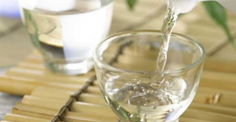Chai rượu Vodka và chiếc ly, biểu thị việc sử dụng rượu Vodka để làm trắng áo.