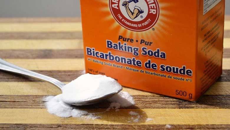 Baking soda dạng bột trắng tinh trong bát nhỏ, chuẩn bị cho việc loại bỏ vết bẩn trên áo trắng.