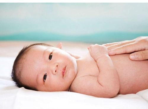 Người lớn thoa kem dưỡng ẩm cho trẻ sơ sinh, minh họa cách sử dụng kem dưỡng ẩm đúng cách để chăm sóc da bé